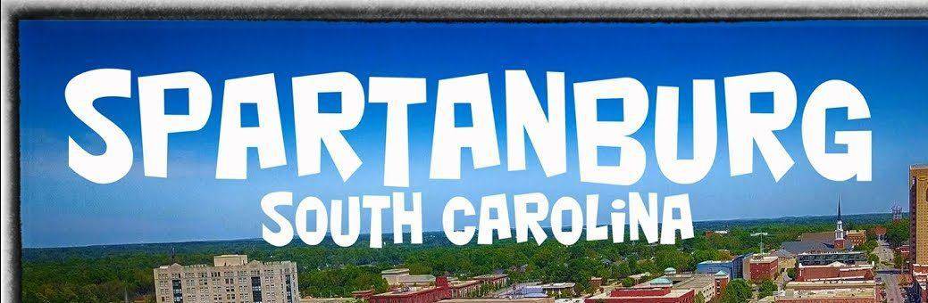 Spartanburg South Carolina cityscape with large street sign, urban skyline and downtown area.